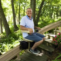 man riding on Bruno outdoor curved stairlift installed by Lifeway Mobility