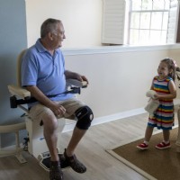 man sitting on Harmar Helix at top park position smiles at grandaughter