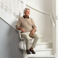 man riding Otolift stair lift by Lifeway Mobility