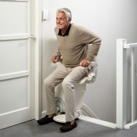 man standing top of stairs on Otolift stairlift by Lifeway Mobility