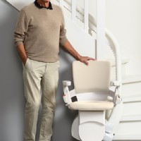 man standing next to Otolift curved stair lift by Lifeway Mobility