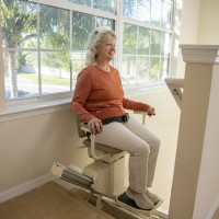 woman riding Harmar SL 600HD stairlift from Lifeway Mobility