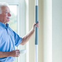 man holds onto super pole while drinking coffee