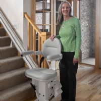 woman standing beside her new Bruno elite stairlift