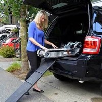 woman putting stair trac into trunk of vehicle