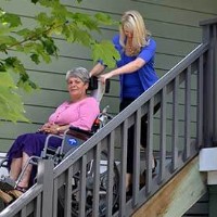 woman using stair trac to safely transport disabled mom down stairs