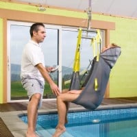 aregiver assisting woman in pool with pool lift