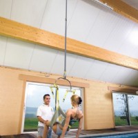 man helping woman safely transfer using pool lift