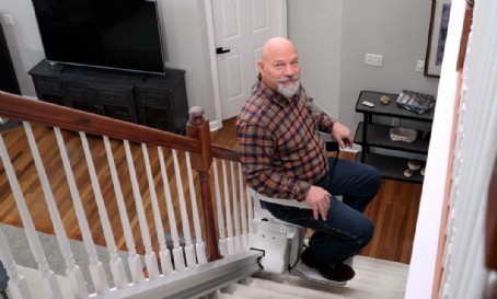 senior watching wife ride up stairs on new Bruno Elan stairlift