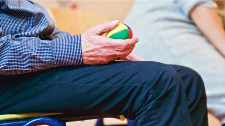 senior man holding stress ball for wrist therapy