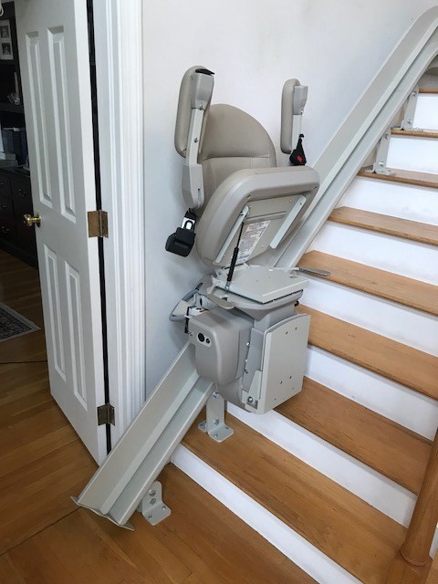 Bruno curved rail stairlift in Andover Massachusetts with seat and armrests folded up