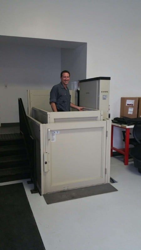 Commercial VPLs/Tesla Motors employee using EHLS installed wheelchair lift to access raised entrance