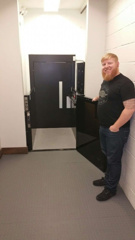 Goose Island employee standing next to commercial wheelchair lift built in hositway by Lifeway Mobility Chicago