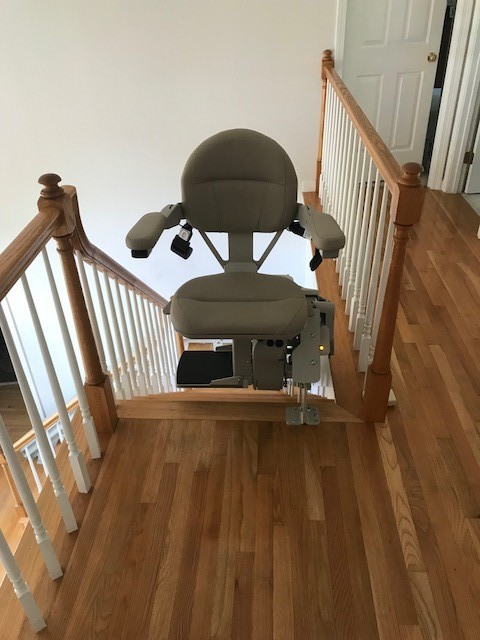 curved-stairlift-in-Massachuetts-at-top-landing-with-seat-swiveled-away-from-the-stairs.jpg