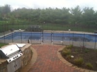 Protect A Child mesh pool fence with brick path