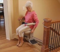 Bruno-Elite-Indoor-Straight-stairlift-with-lady-showing-swivel-seat-at-top-landing.jpg