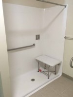 accessible shower with rubber threshold grab bar and shower bench