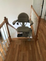 curved-stairlift-in-Massachuetts-at-top-landing-with-seat-swiveled-away-from-the-stairs.jpg
