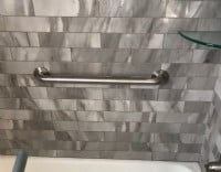 polished grab bar installed horizontally in bath tub in Minnesota home