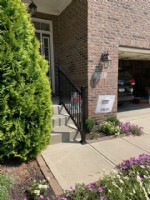 single handrail on concrete stairs leading to front door