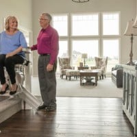 senior watching wife ride up stairs on new Bruno Elan stairlift