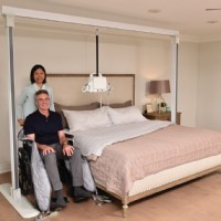 Savaria Portable Ceiling Lift with caregiver assisting man in wheelchair