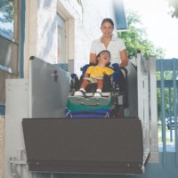 Mom Helping Boy on Outdoor Bruno 3100 vertical platform lift