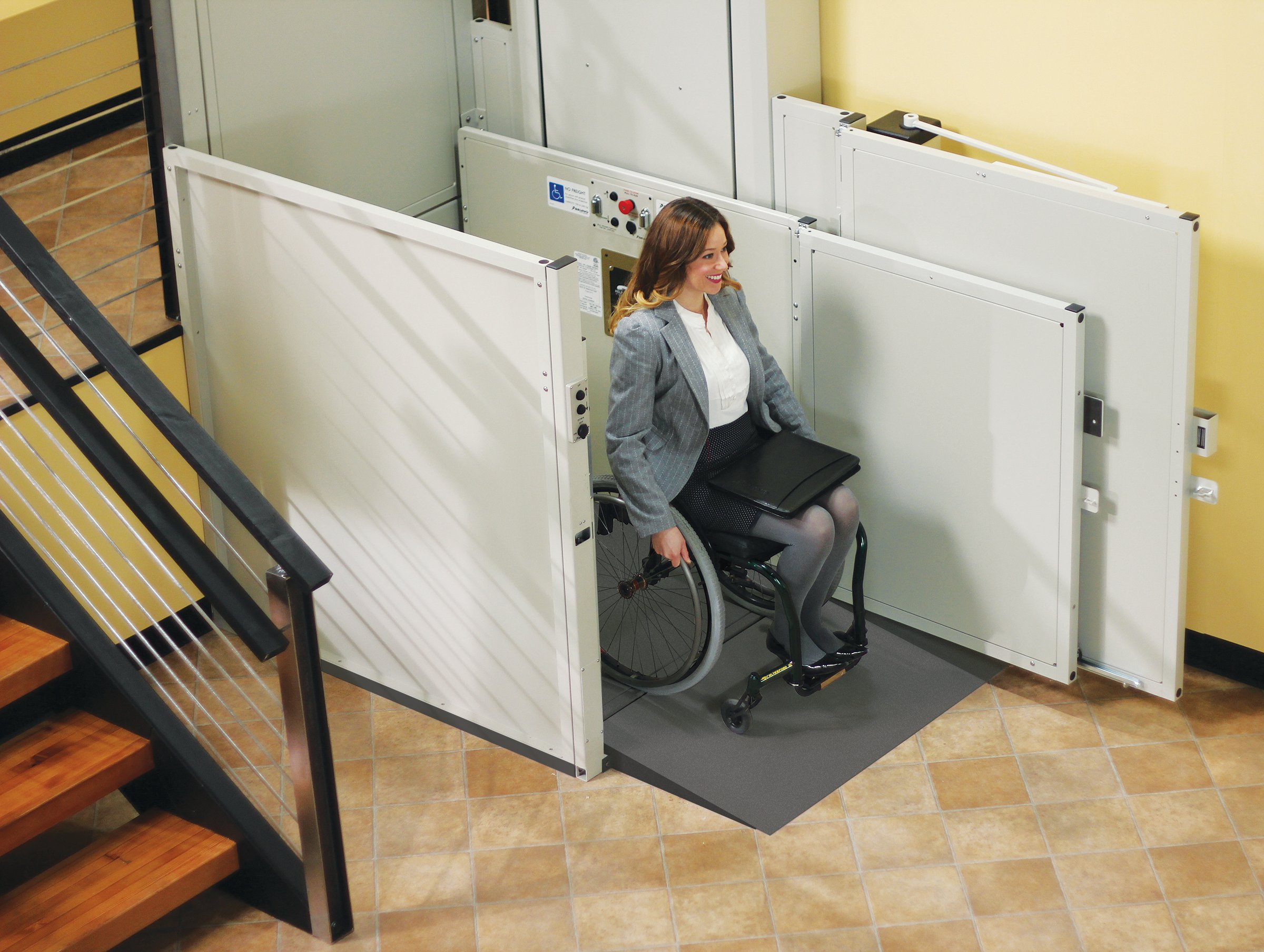 woman in a wheelchair exiting a commercial wheelchair lift in her office building
