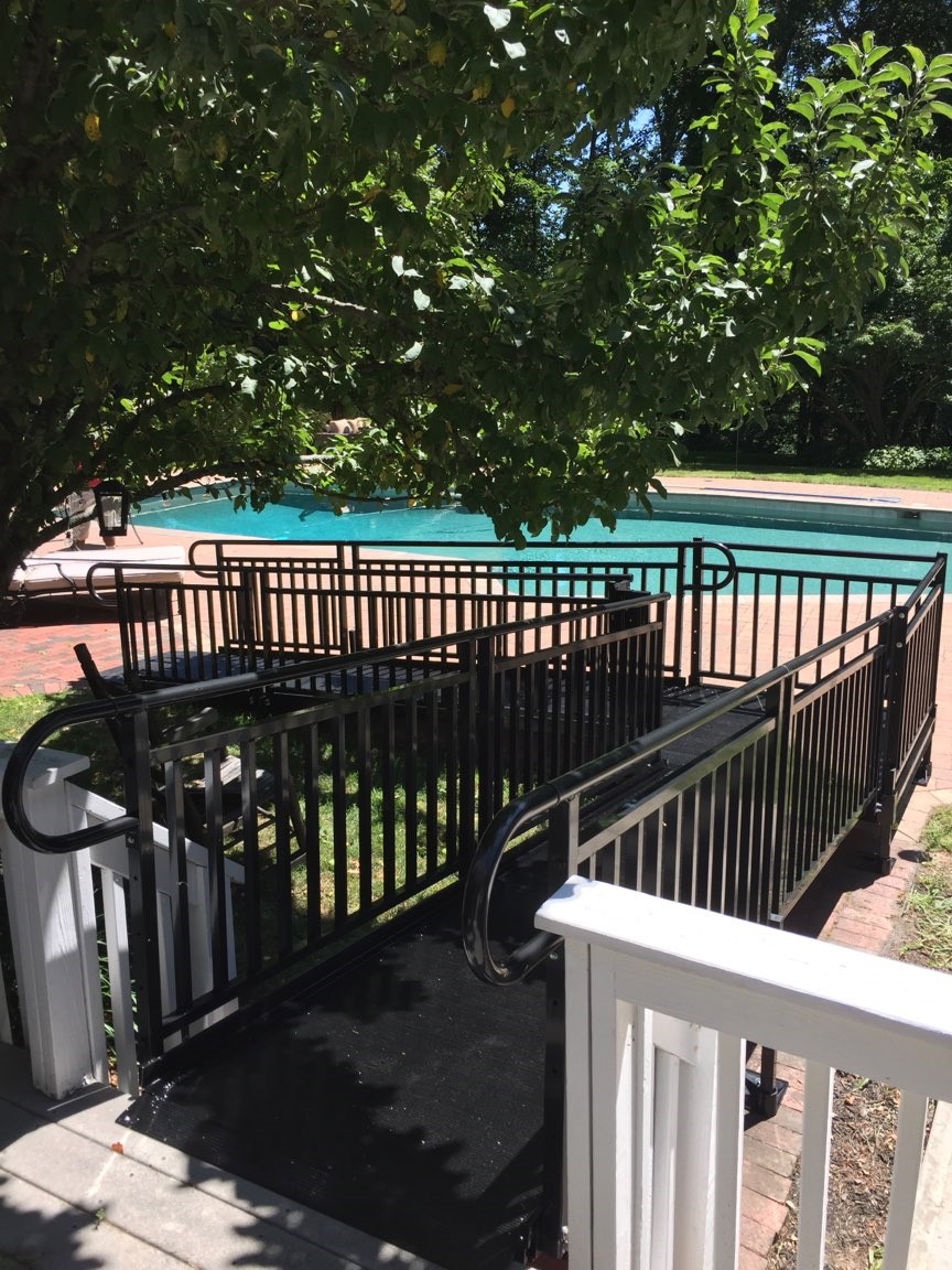 black-aluminum-modular-ramp-providing-access-to-pool-in-backyard