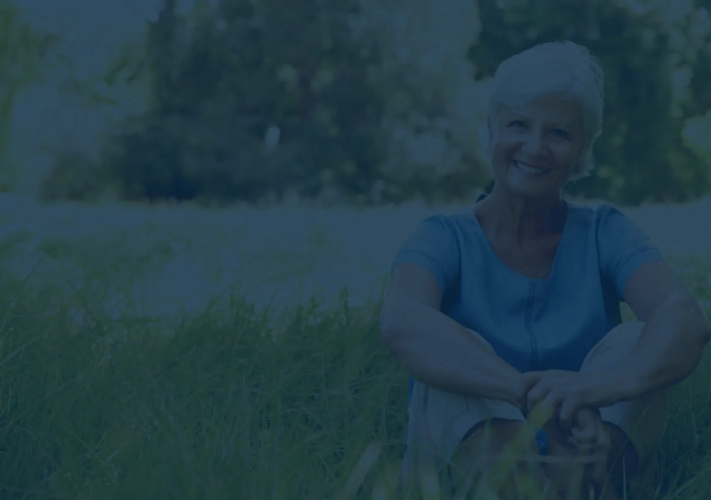 Woman smiling sitting in a field
