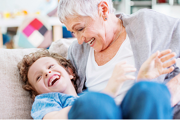 older adult laughing with grandson